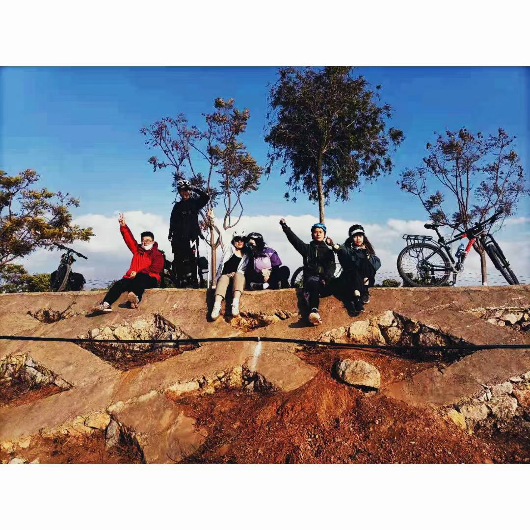 A group of cyclists taking a break together beside their bicycles